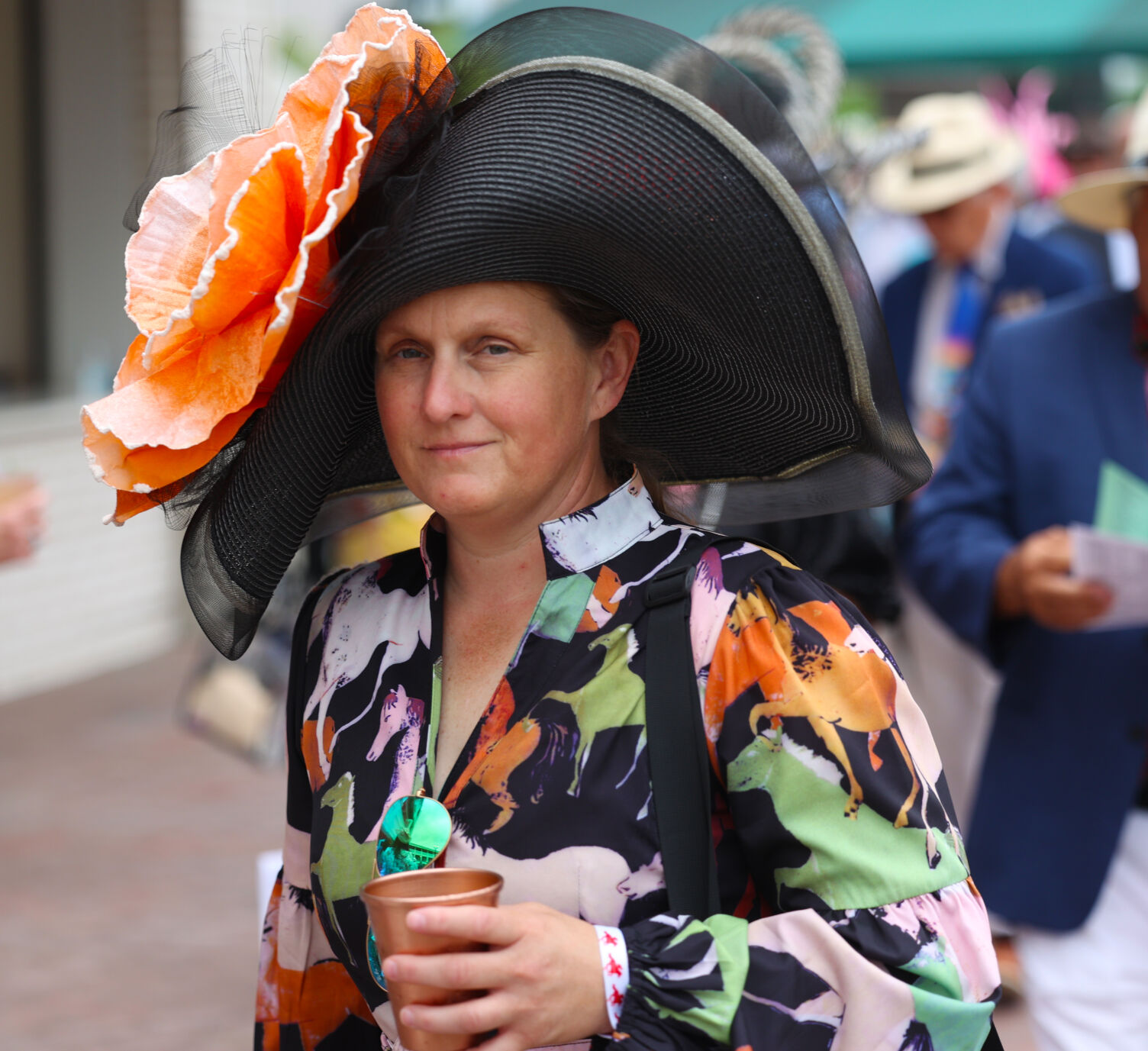Woman with big derby hat looks at camera.JPG
